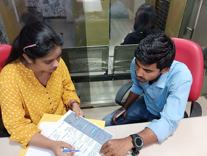 A TGC team member reviewing printed work with a student
